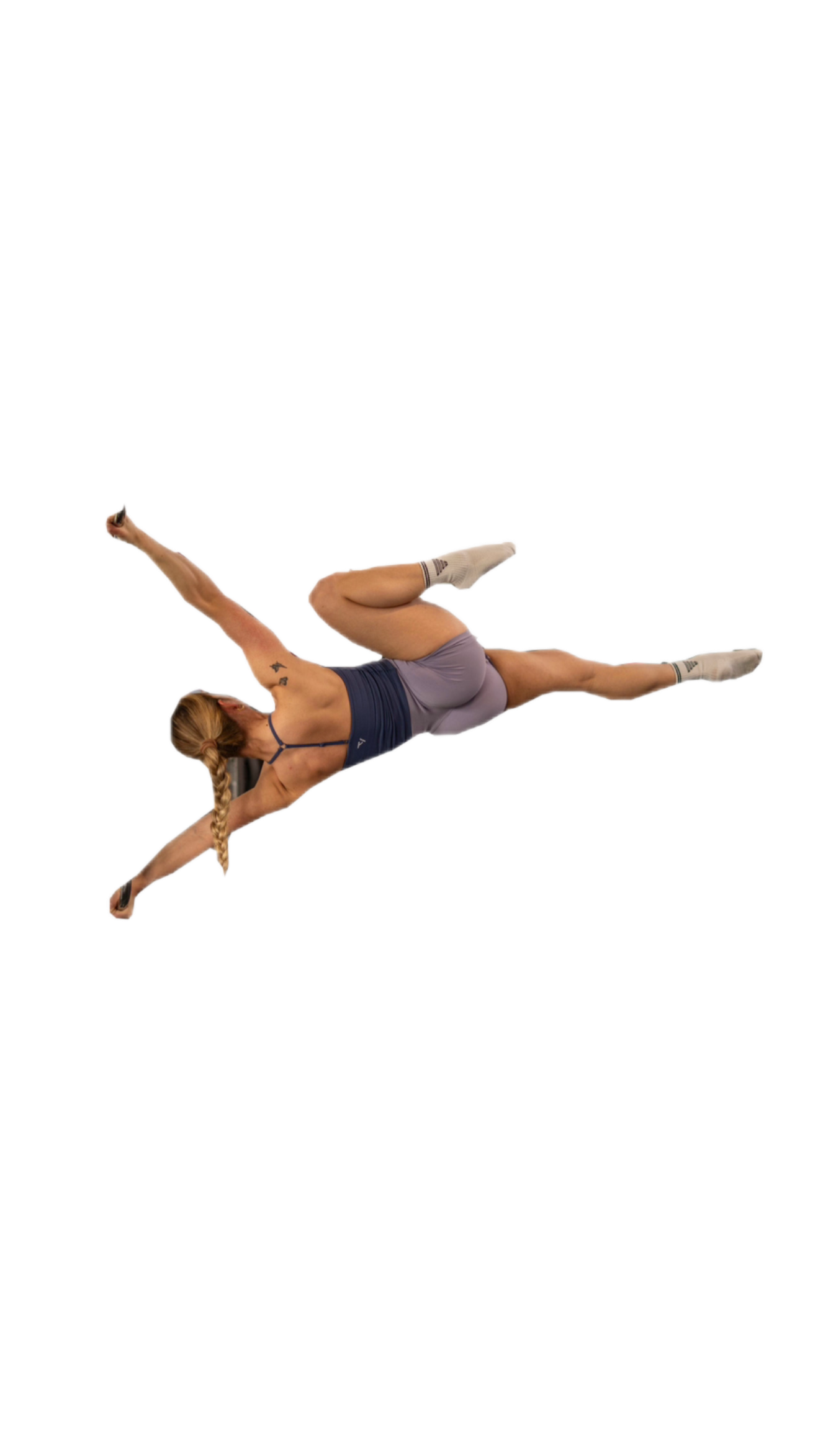 A woman with a braided ponytail performs a dynamic, mid-air jump against a white background.