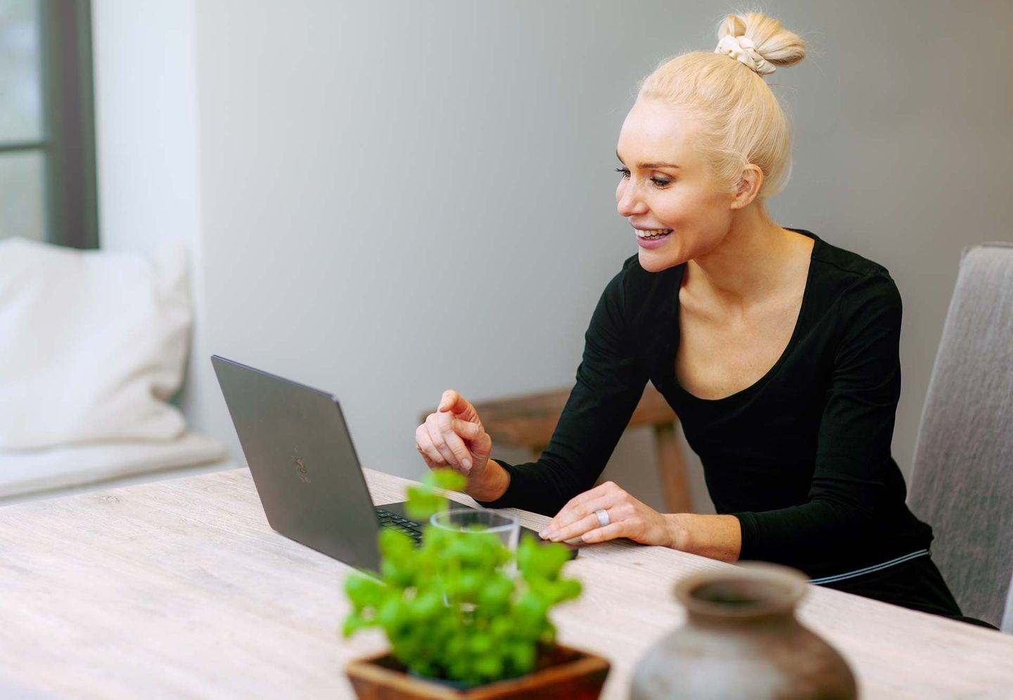 En smilende træner arbejder på en laptop ved et skrivebord.