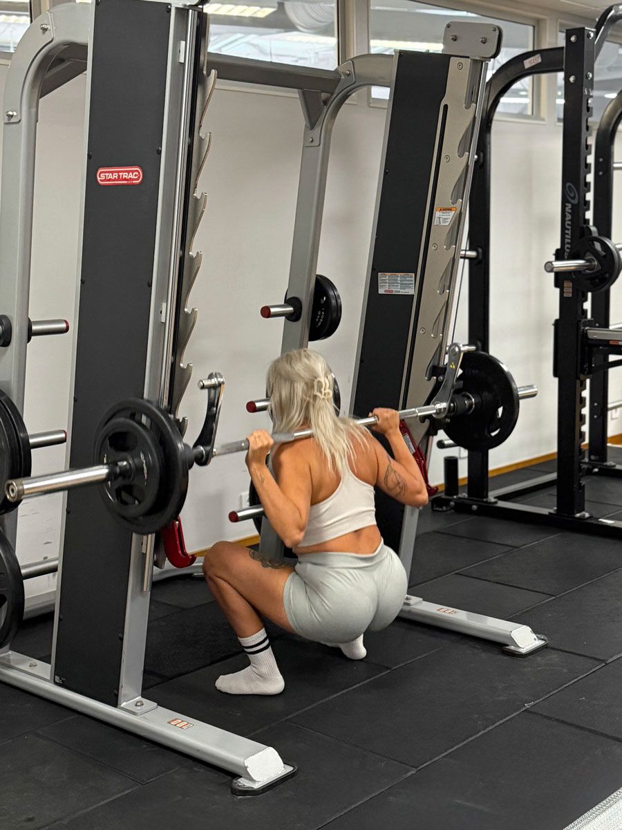 Tränaren tränar på gymmet.