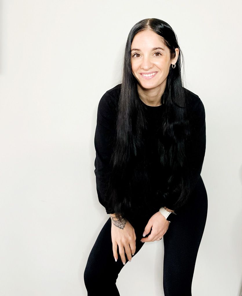 Coach is posing in a black outfit with a big smile.
