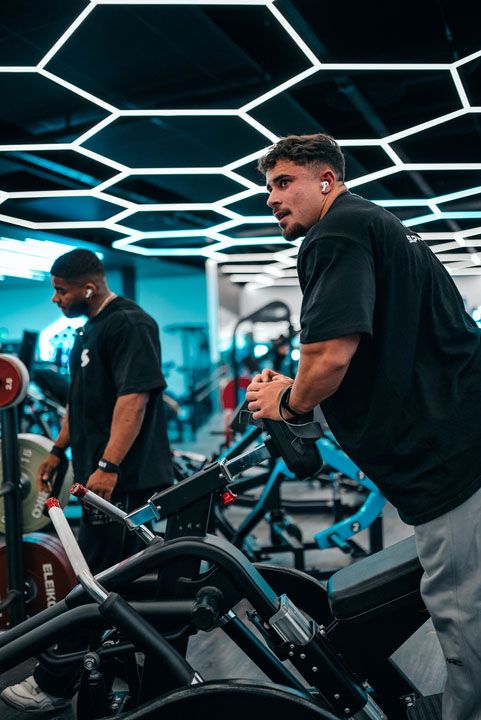 Coachen lyfter sitt IFBB Pro Card över huvudet på tävlingsscenen.