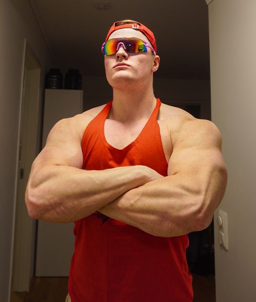 Coach is flexing is muscles with sunglasses on.