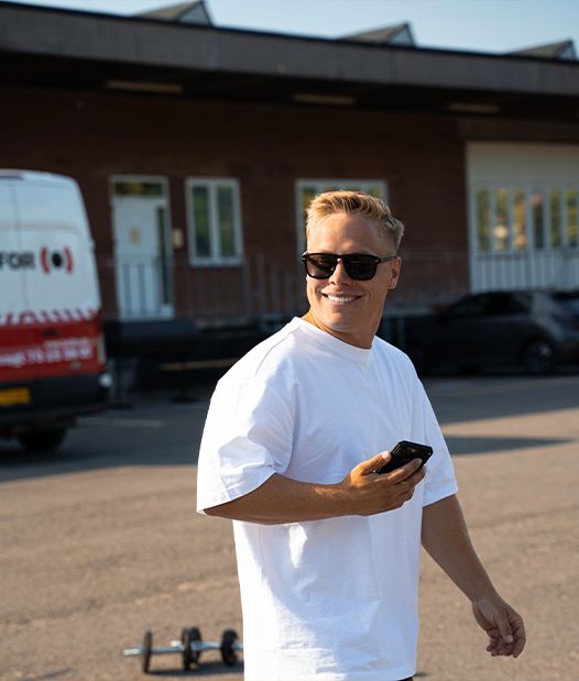 Coachen er udenddørs smilende med solbriller