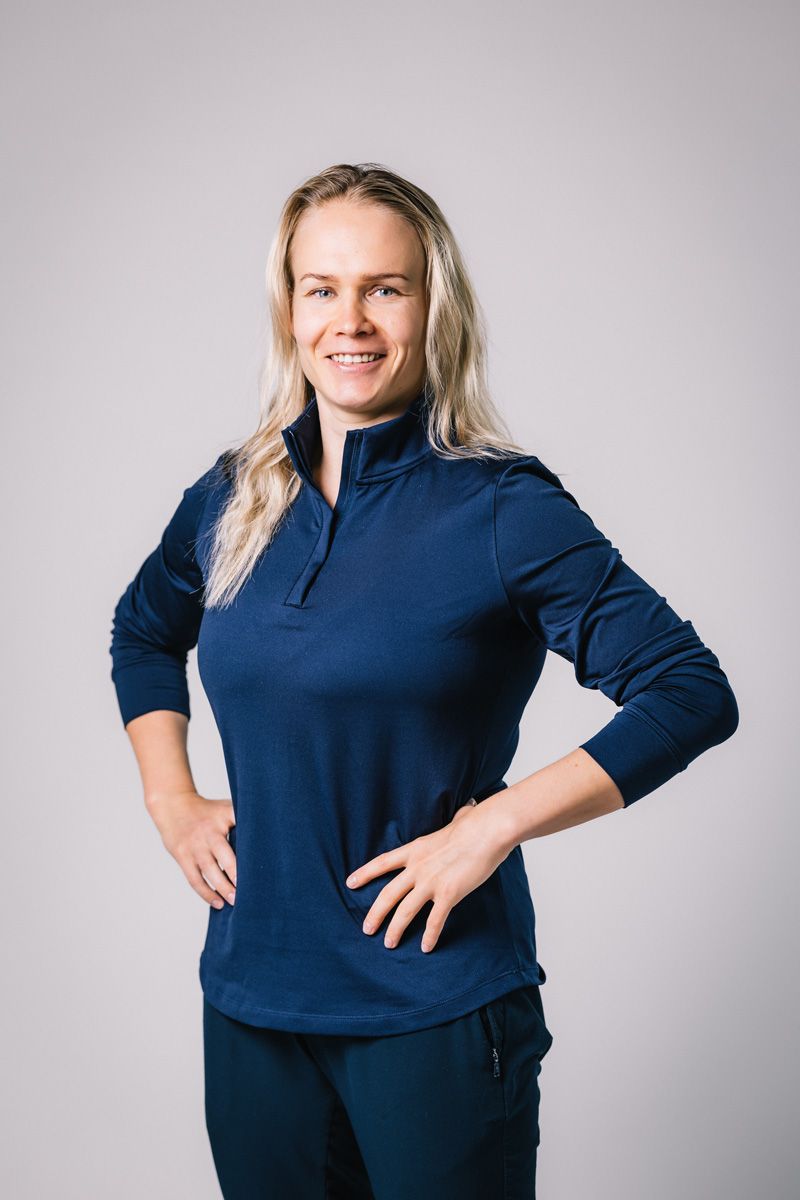 Valmentaja seisoo kädet ristissä