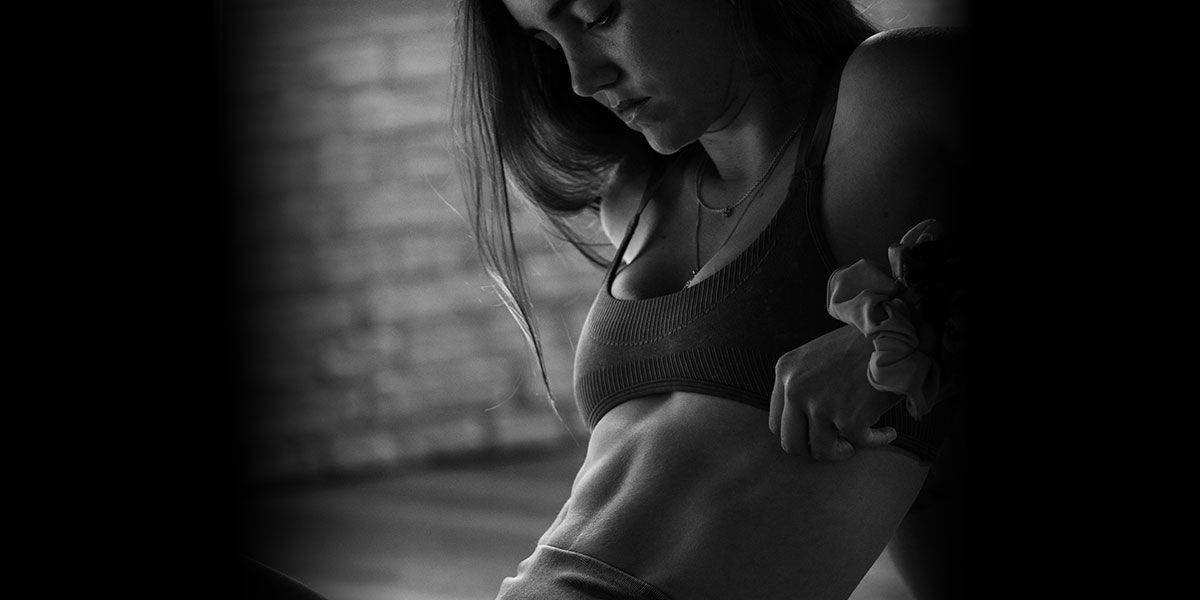 La entrenadora está mostrando el músculo de su espalda.