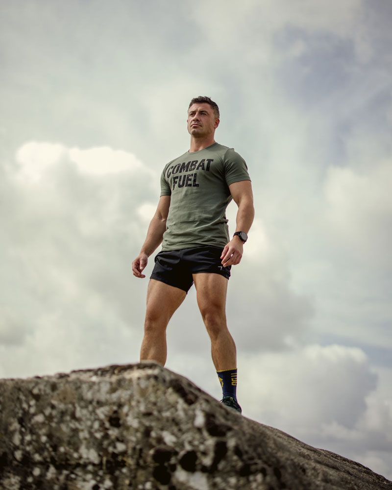 A picture of the coach standing on a rock