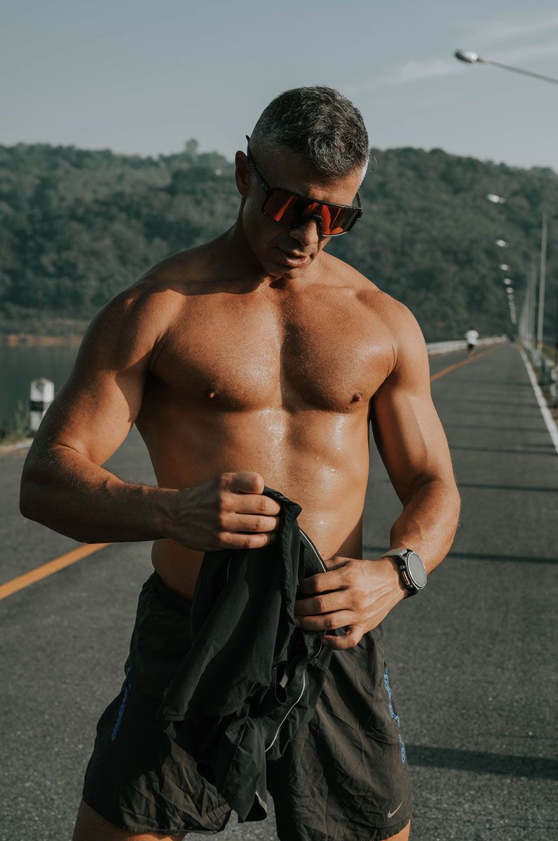 The coach is posing with shirtless.