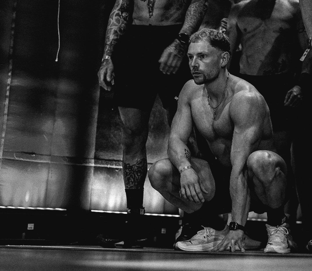 The coach is looking at something while sitting.