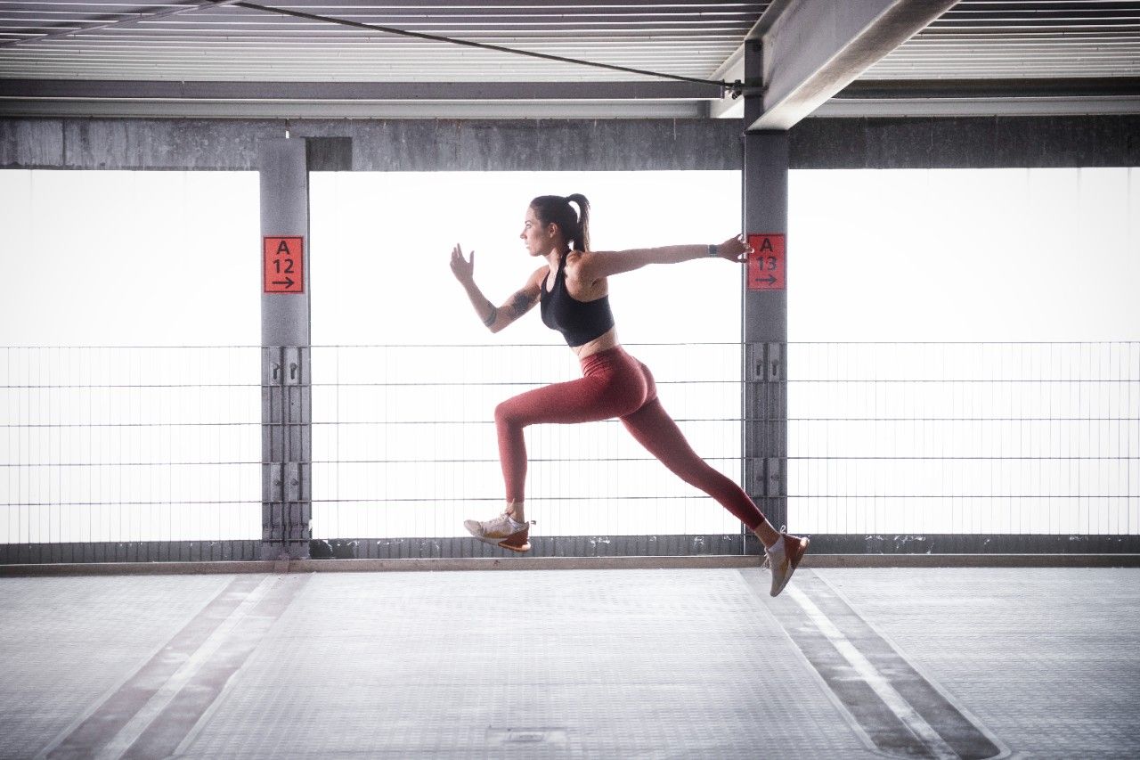 Maren Naue beim Training mit Kettlebell, Plank-Position in einem hellen Parkhaus