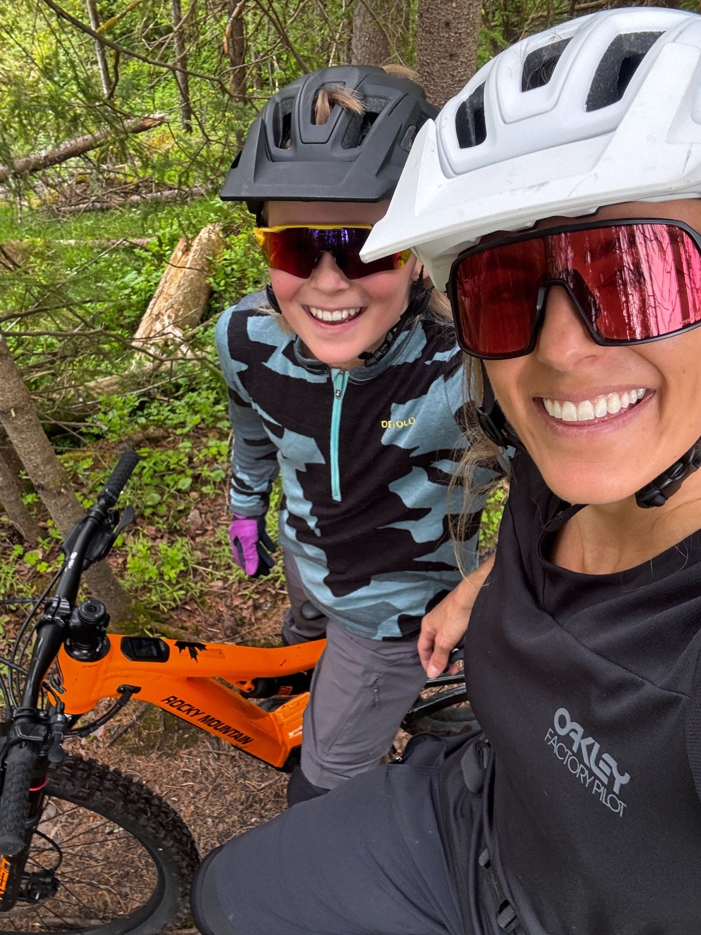 Savannah and her child smiling during a forest bike ride