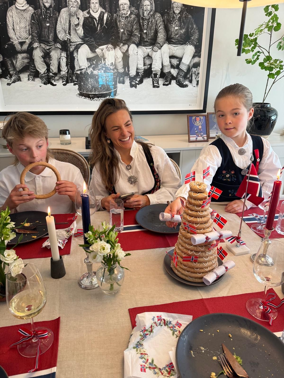 Savannah celebrating with her children around a table decorated with Norwegian flags