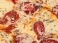 Close-up view of a pepperoni pizza with melted cheese and herbs.