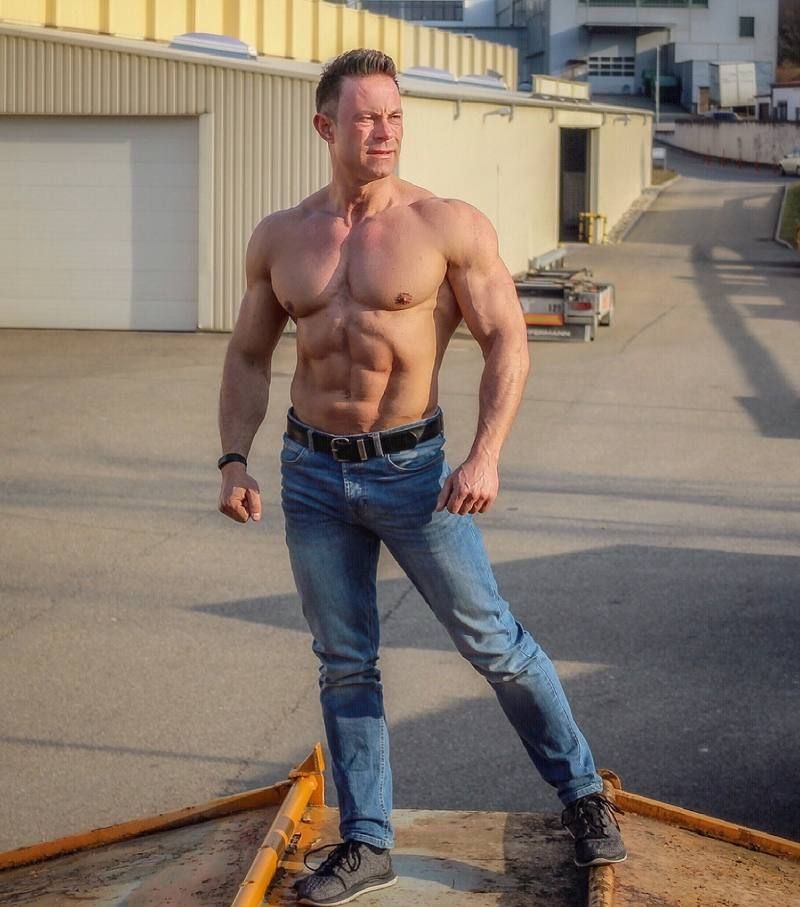 Albert Häußler mit freiem Oberkörper vor einer Garage